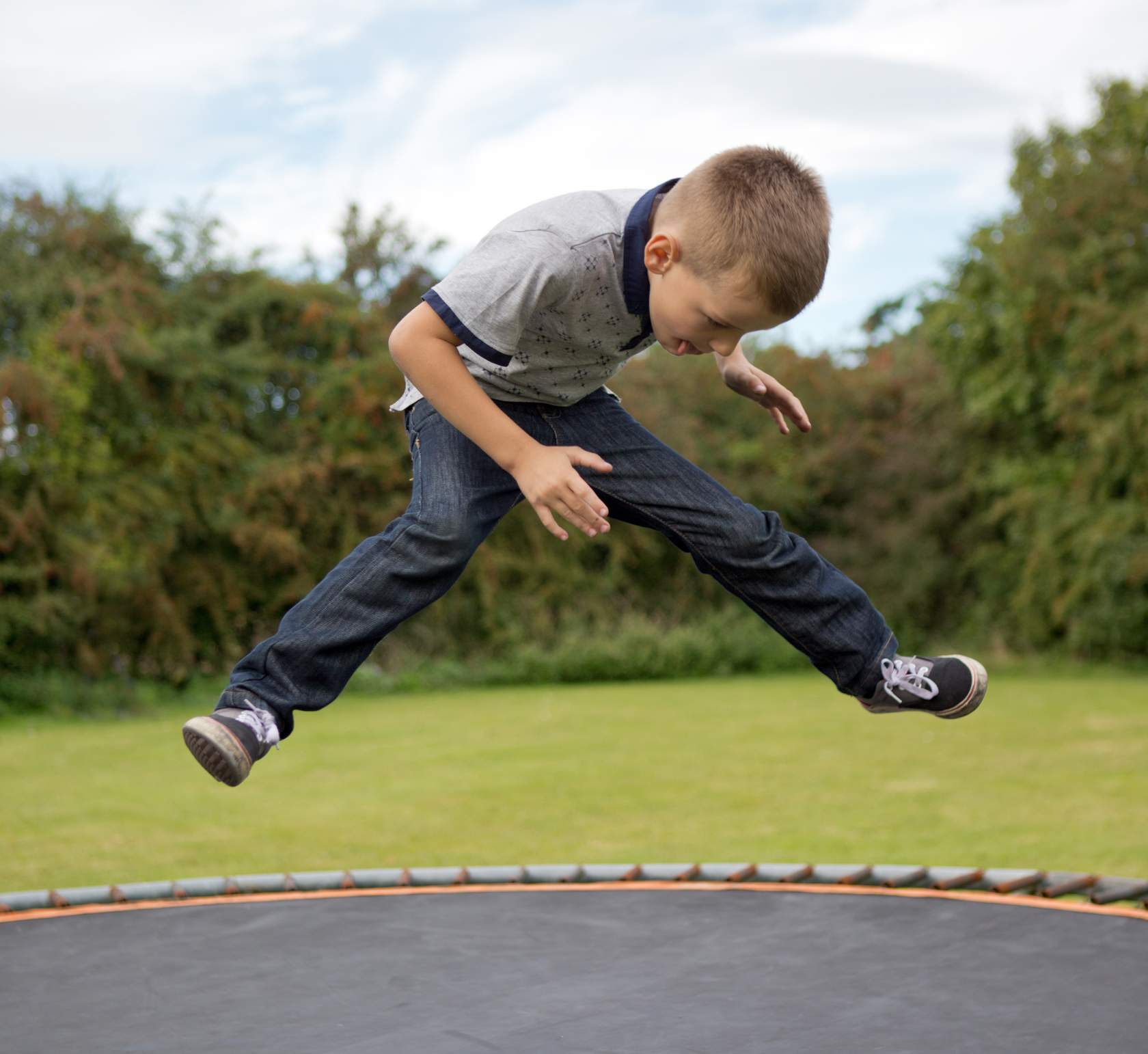 A boy experiencing joy while jumping on a trampoline.