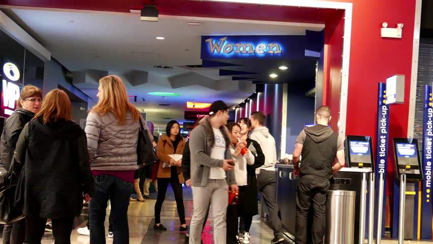 A group of people standing in line at a theater.