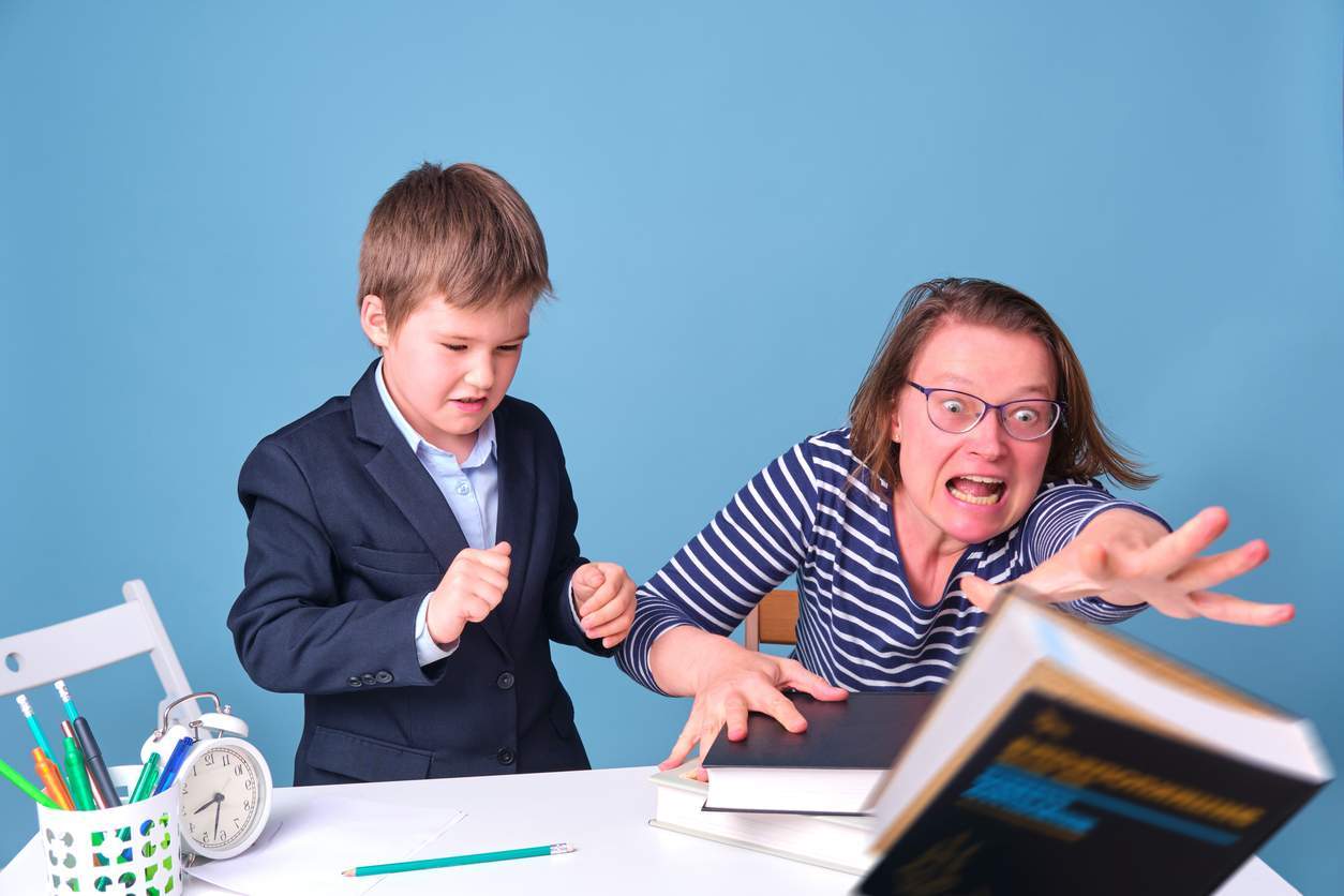 A woman demonstrating fluency and flexibility with SEO techniques, sitting at a desk with a boy.